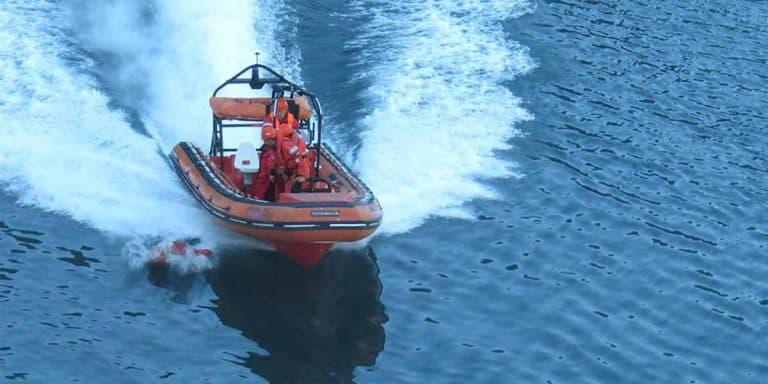 Man overboard drill with rescue boat recovering a dummy from the water