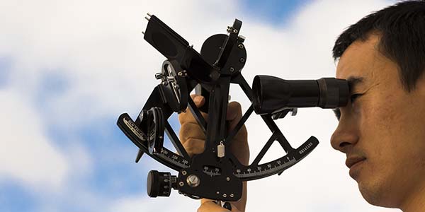 Close up of officer using a sextant