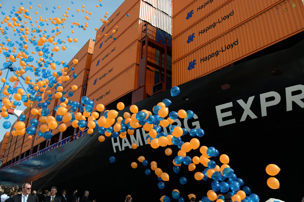 A photograph showing orange and blue balloons being released during the christening of the container ship Hamburg Express