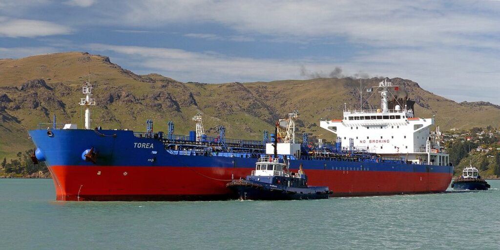 A photograph of the oil tanker 'Torea' with a red hull and blue superstructure